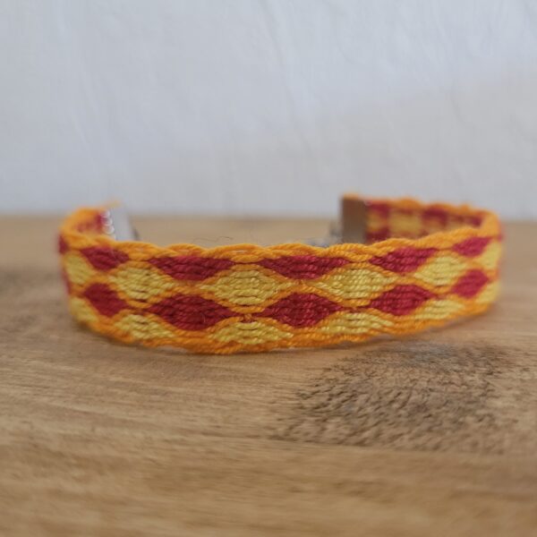 photo d'un bracelet à carreaux rouge et jaune avec une bordure orange