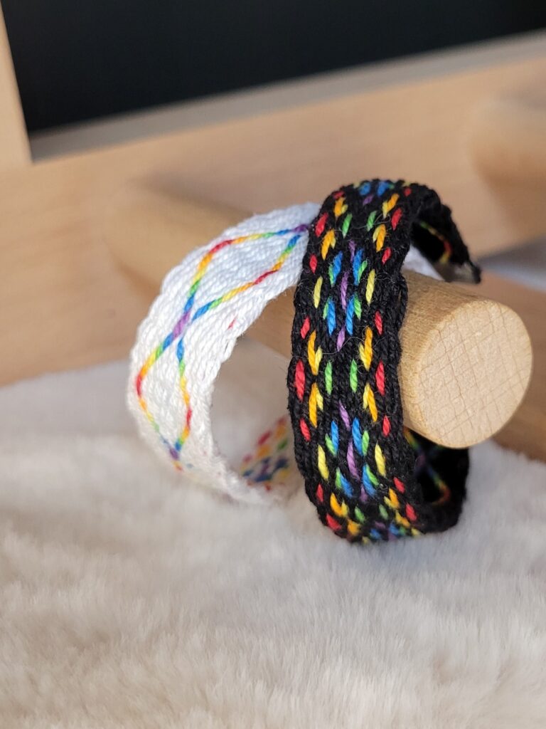 photo de deux bracelets tissés aux cartes avec les couleurs de l'arc en ciel