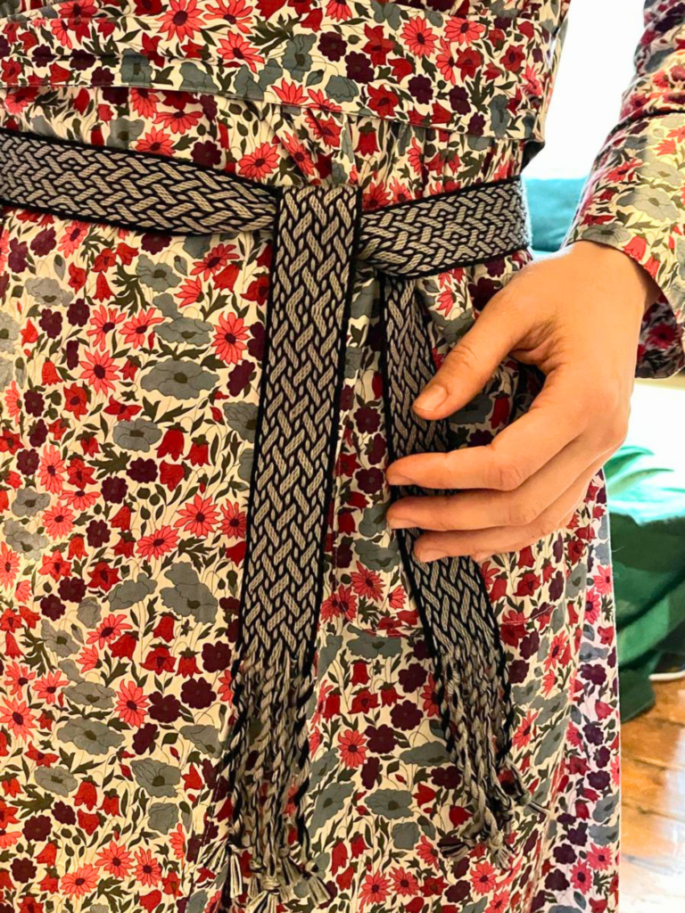 photo d'une ceinture tissée aux cartes grise et noire sur une robe à fleurs