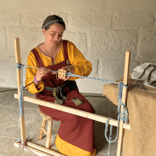 photo d'une démonstration de tissage aux cartes en costume médiéval